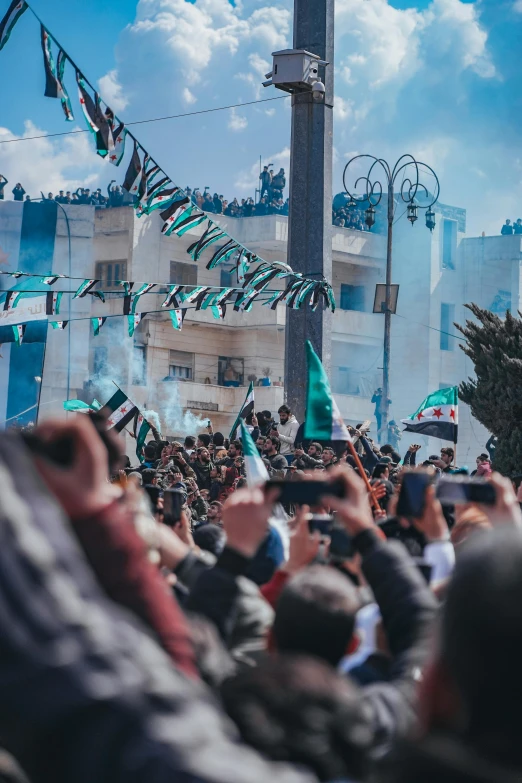 a crowd with people watching flags and banners