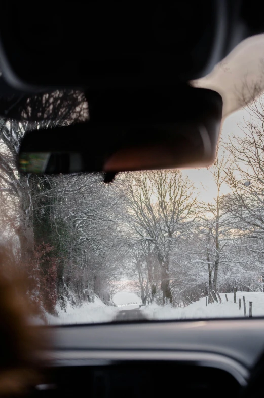 the view from inside a vehicle looking out on a snow covered road