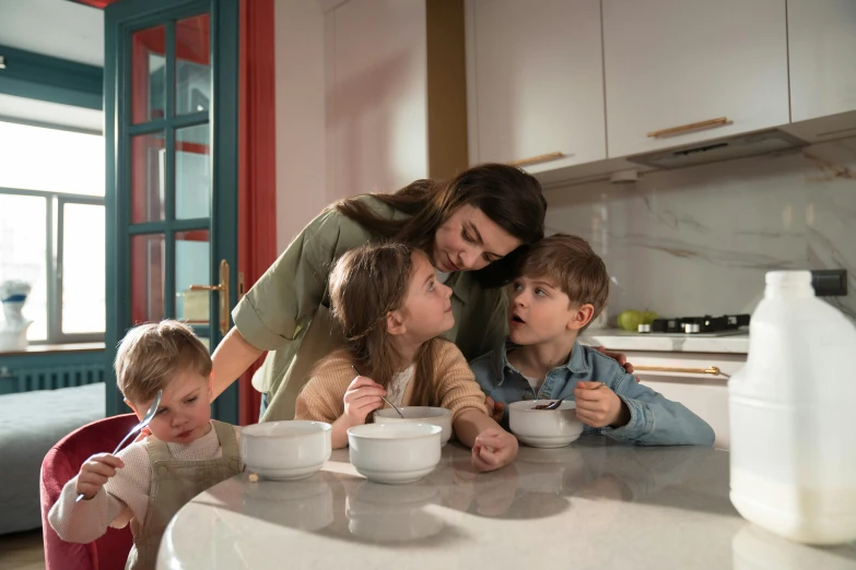 a woman is feeding her children while eating