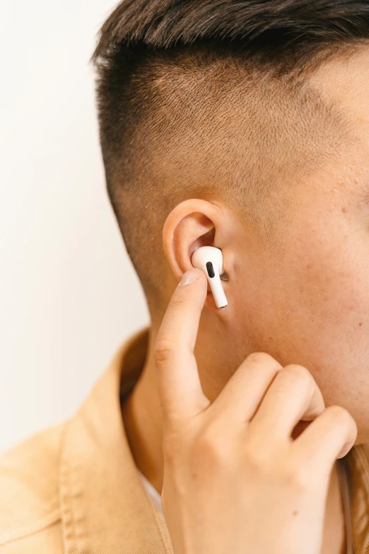 a man holding a cell phone and an ear cord to his ear