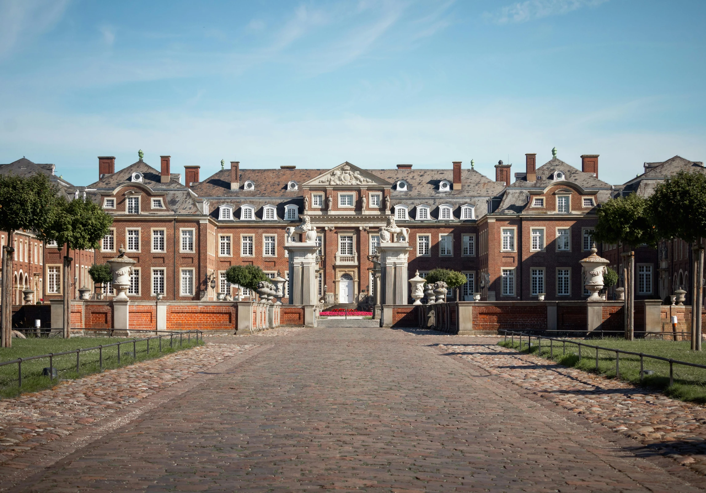 an old mansion surrounded by brick driveway and trees