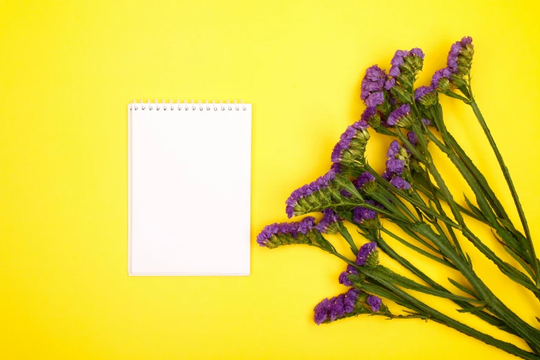 flower arrangement on yellow table next to white paper