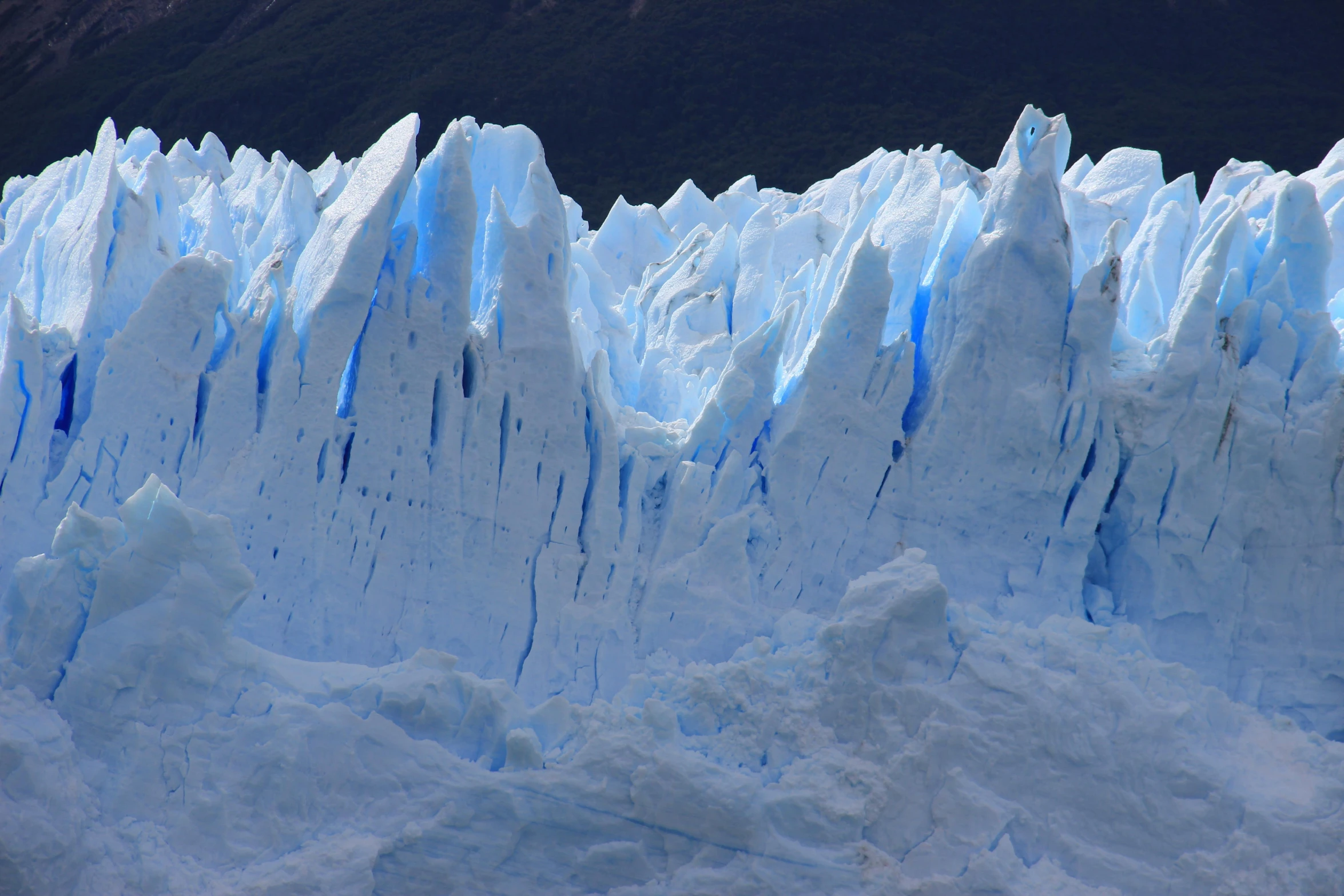 large iceberg with blue and white stripes on its face