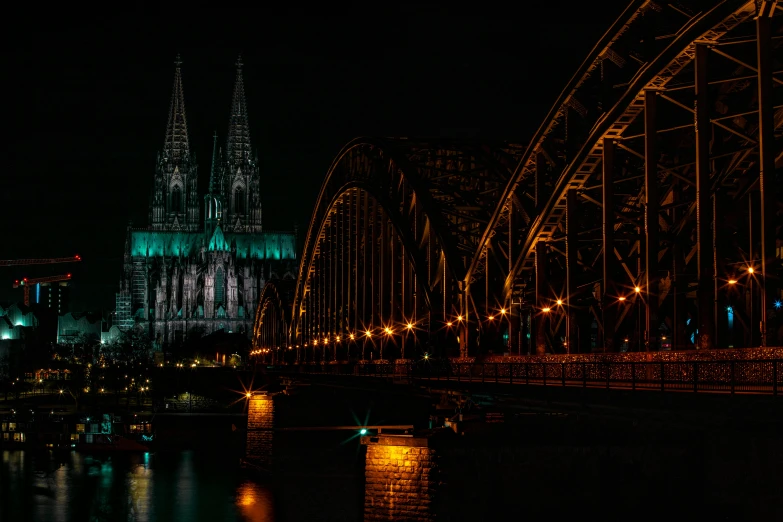 a large bridge crossing over a river with the cologne cathedral in the background