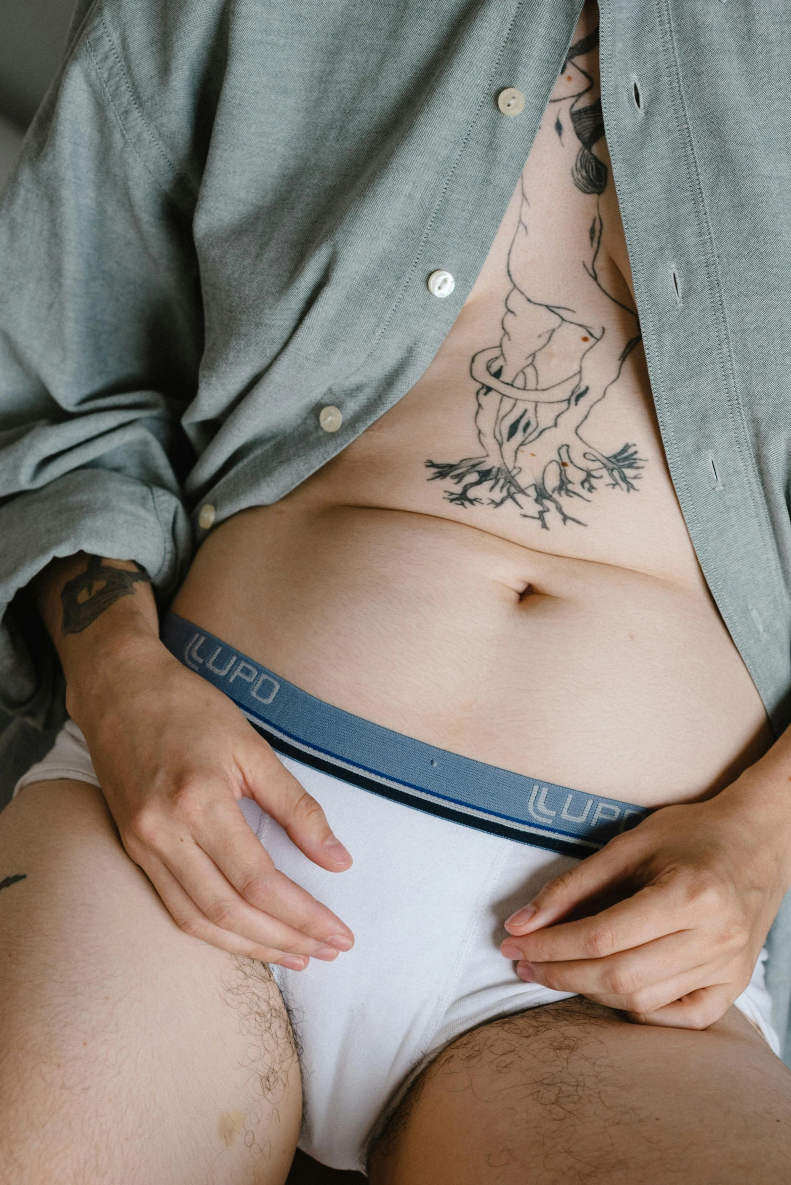 a woman holding a jean panty while laying on a bed