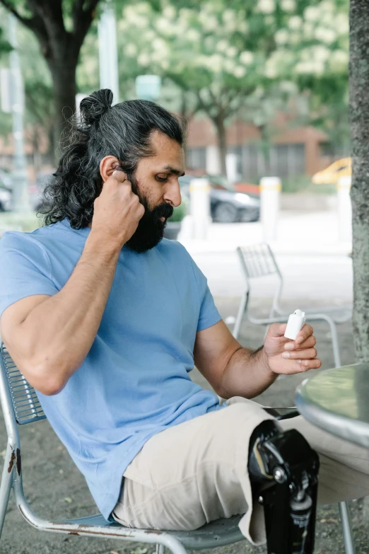 there is a man sitting in a chair while talking on the phone