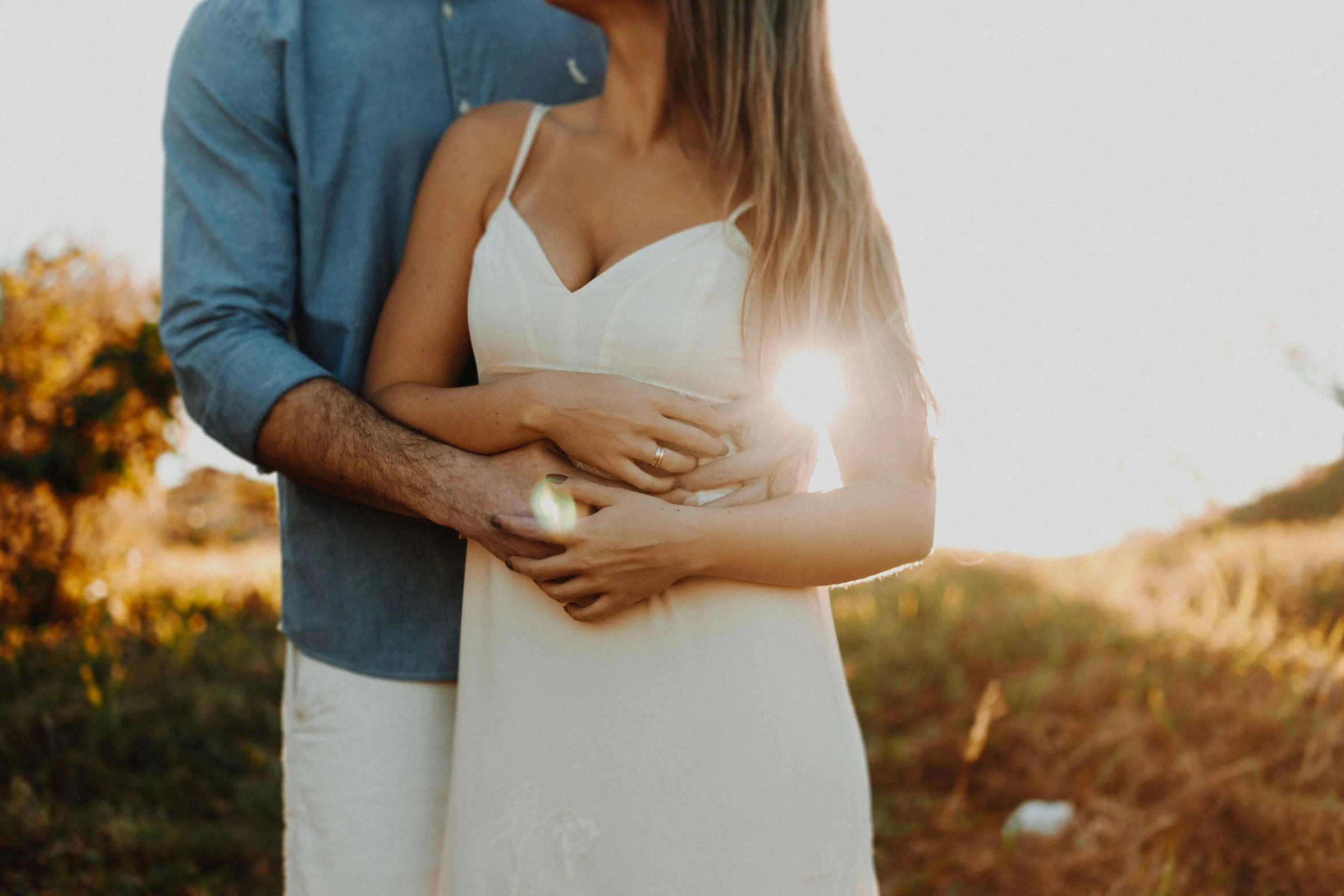 a close - up of a newly married couple's faces as they emce outside on a sunny day