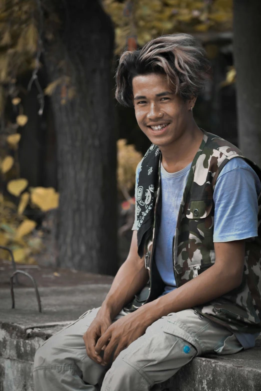 a man sitting on a curb in front of trees