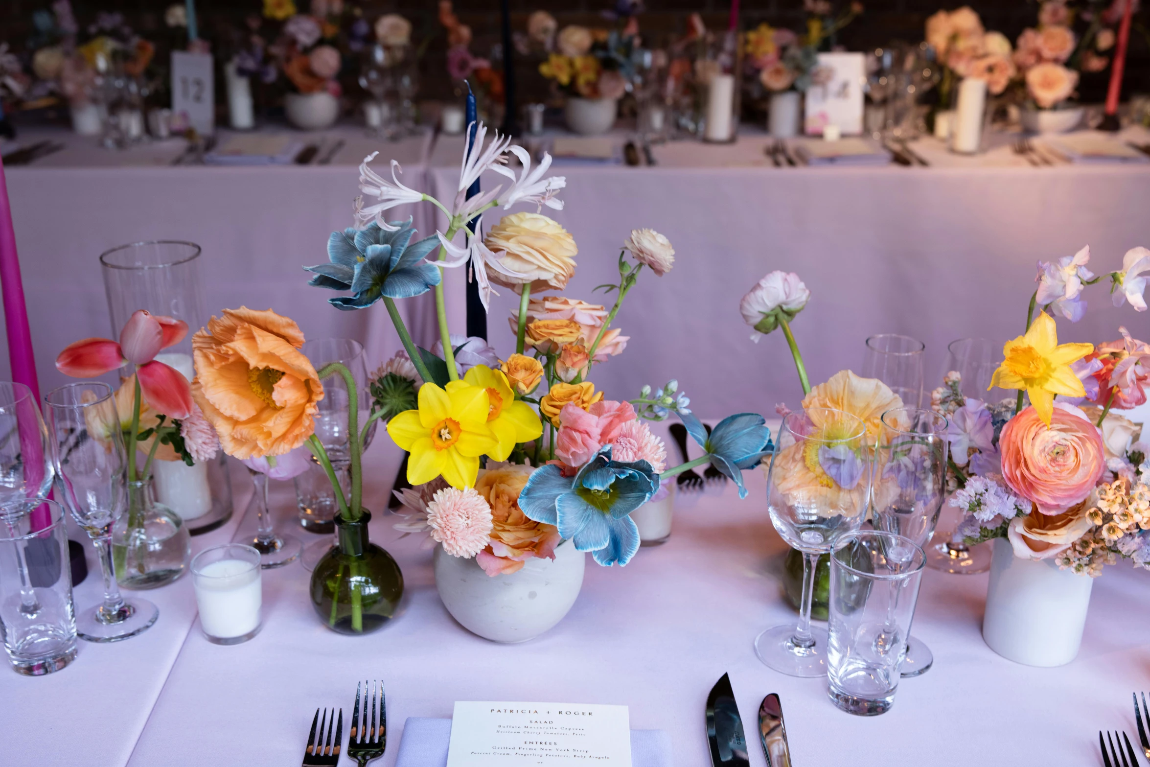 there are many different flowers in vases on this table