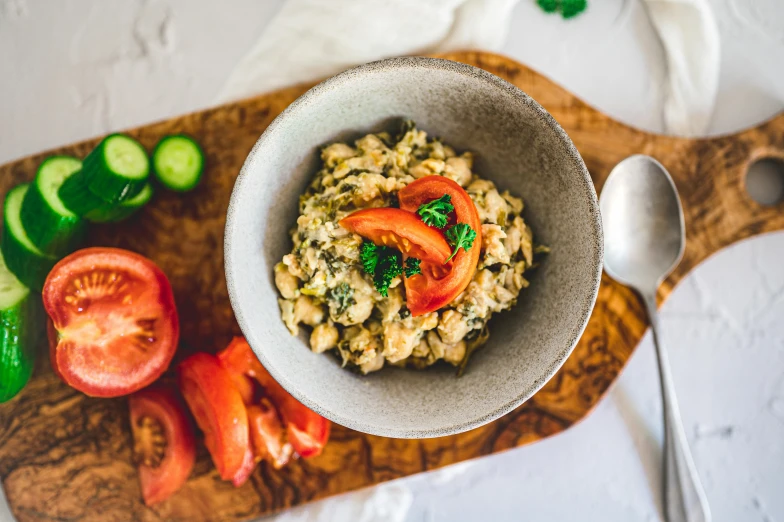 a bowl of some sort on a  board with cucumbers and tomatoes