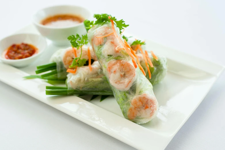 a white plate topped with rolls covered in vegetables