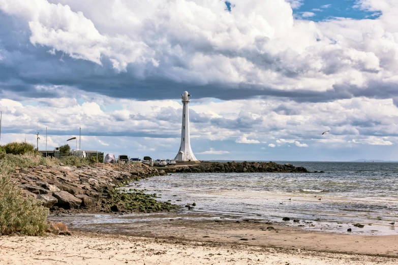 a view from a beach looking towards a light house