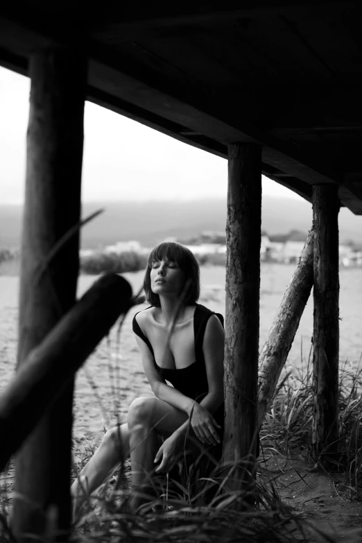 a woman is posing under some poles in the grass