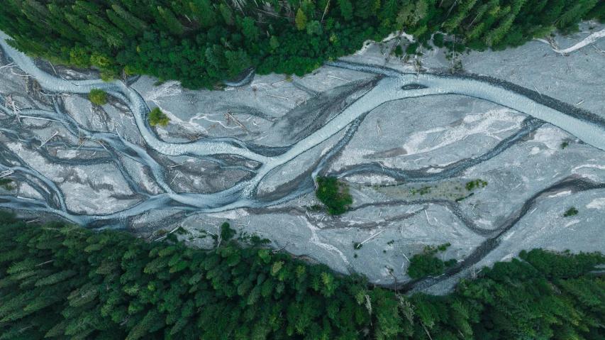 an aerial view of a river flowing through the wilderness