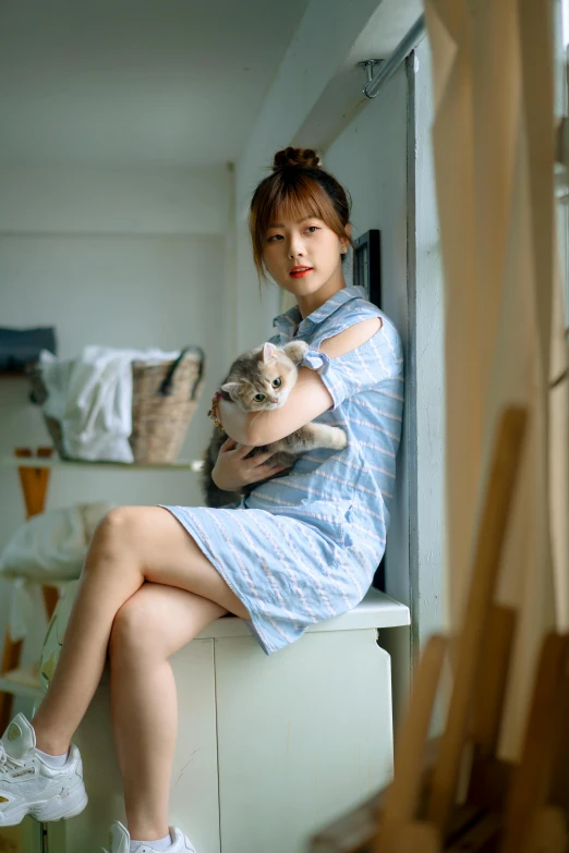 woman sitting on a counter holding a cat