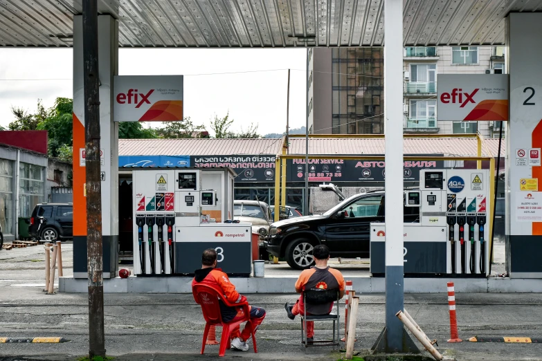 some people sitting at a gas station together