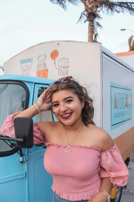 the woman is posing next to a food truck