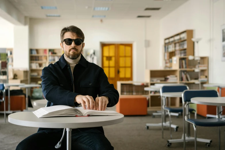 a man sitting down with a book in his lap