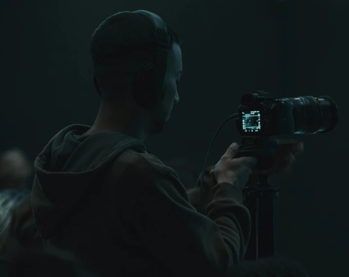 a man takes his po in the dark while a video camera is used to record him