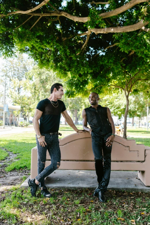 two guys are standing together on the bench