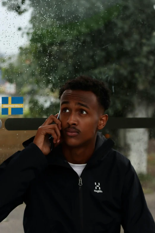 a young man is talking on a cell phone