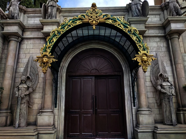 the front door to an old castle with statues on both sides
