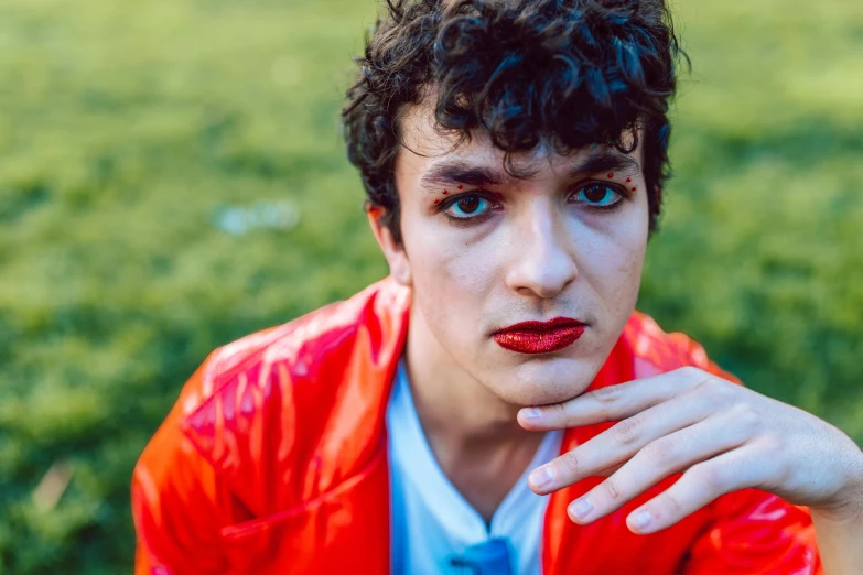 a young man in a bright red jacket with his eyes wide open