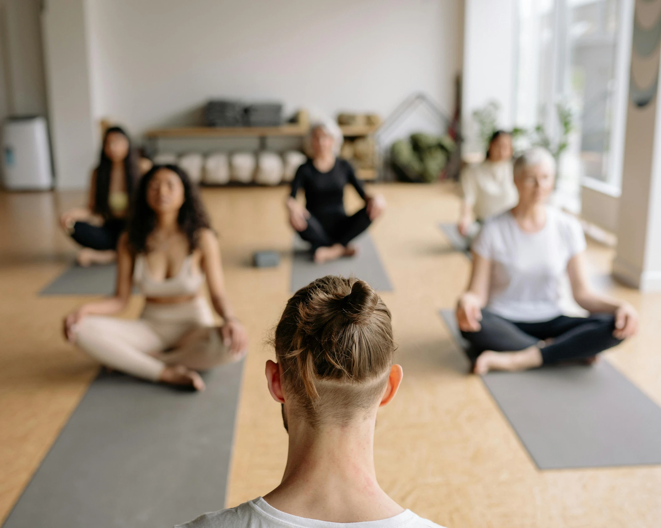 the young men and women are practicing yoga