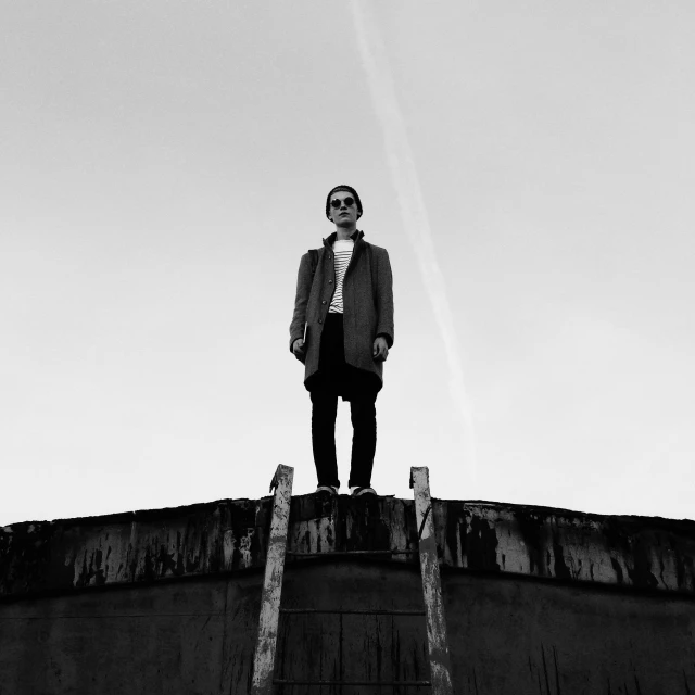 a man standing on top of a rail under a clear blue sky