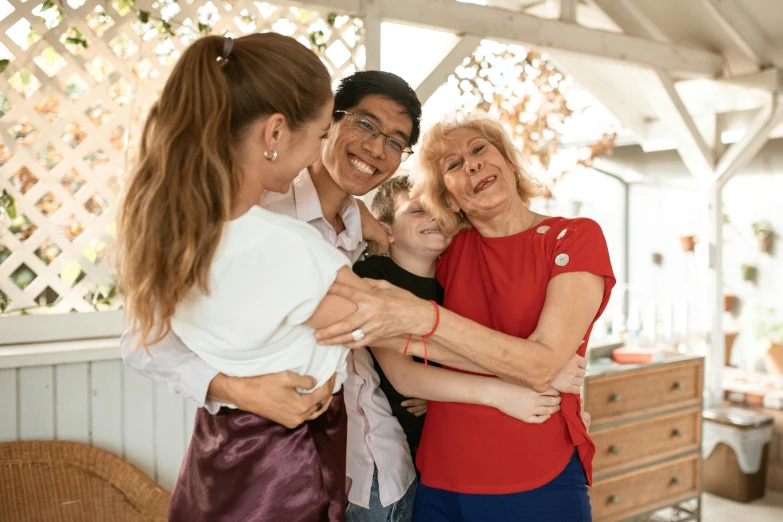 two adults and one child are hugging and laughing