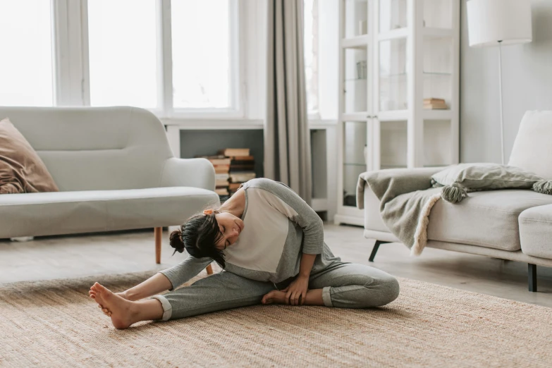 a woman is sitting on the floor in her living room