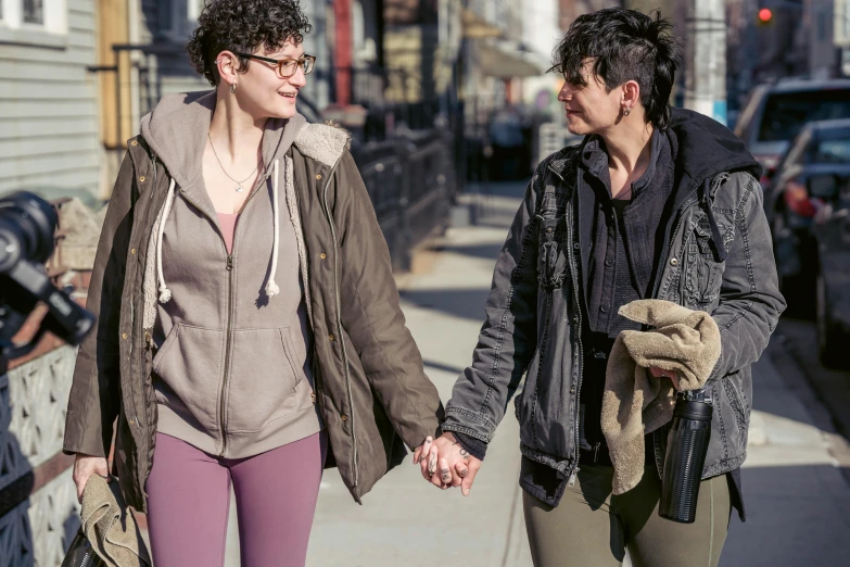 a couple holding hands walk down the street