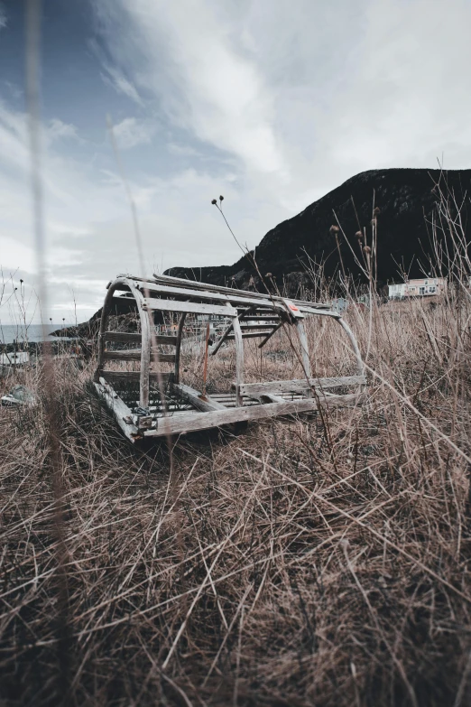 an old metal structure lying in dry grasses