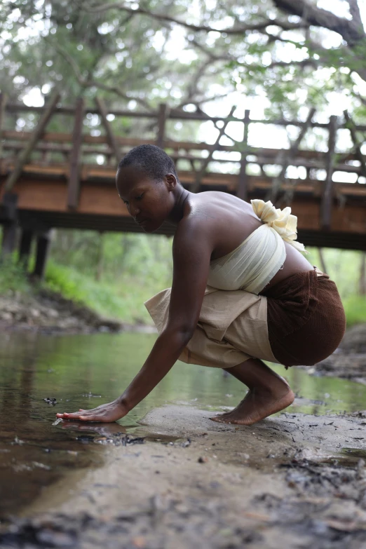 a young man is reaching in the water to find food