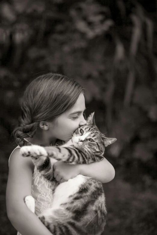 a little girl is hugging her cat in the arms