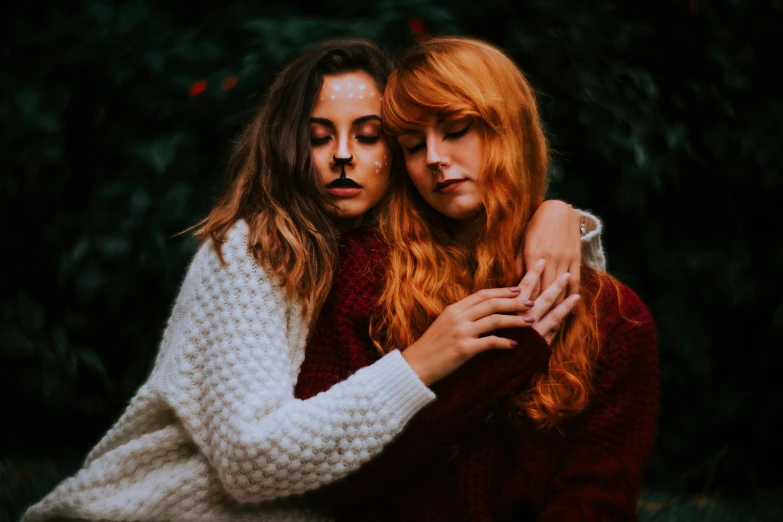 two beautiful women hugging each other outdoors on a sunny day