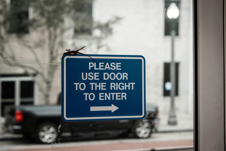 a blue sign hanging from the side of a window