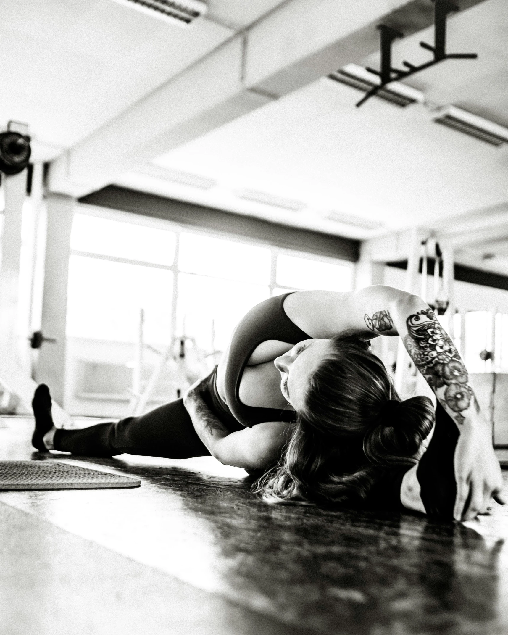 a woman sitting on the floor in front of a yoga mat