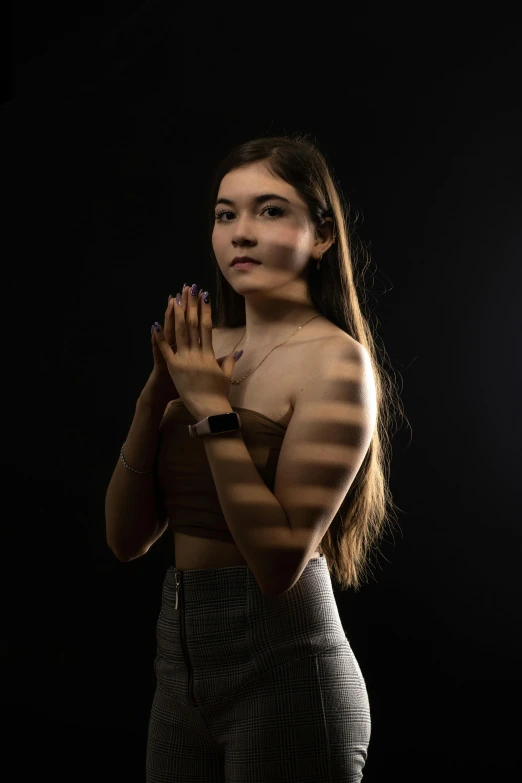 a young woman poses in her underwear with a black background