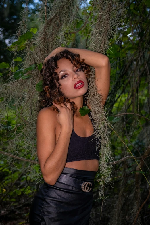 a woman poses in a black skirt and crop top