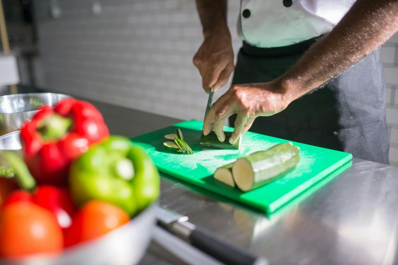 the person is using a knife to cut up veggies