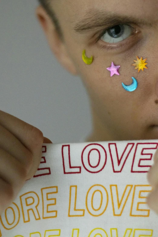 a close up of a person holding a piece of paper with the words i love you