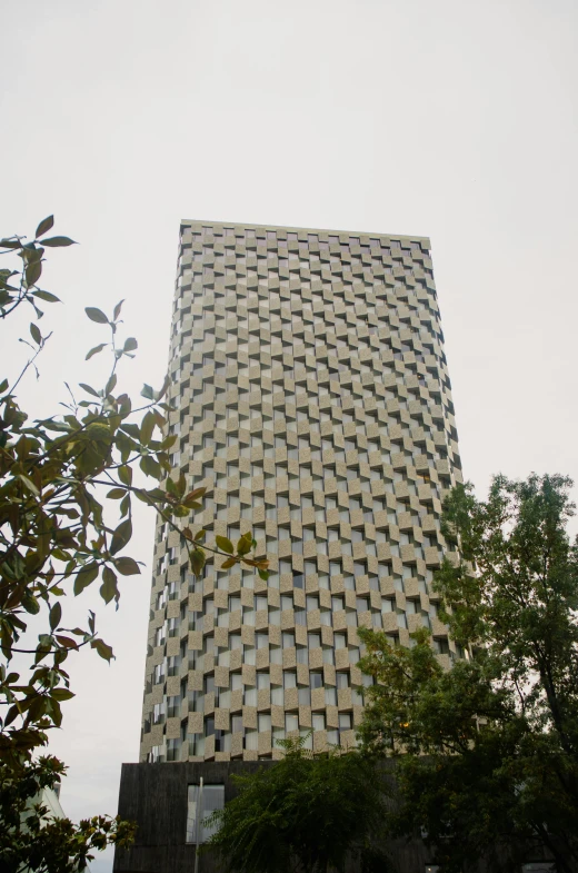 a tall white building with trees and sky in the background