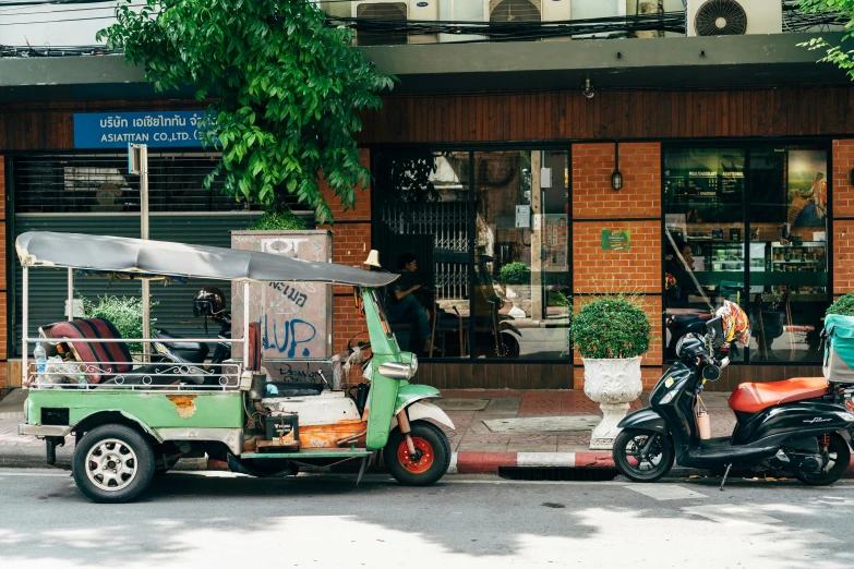 a truck and moped parked in front of a store