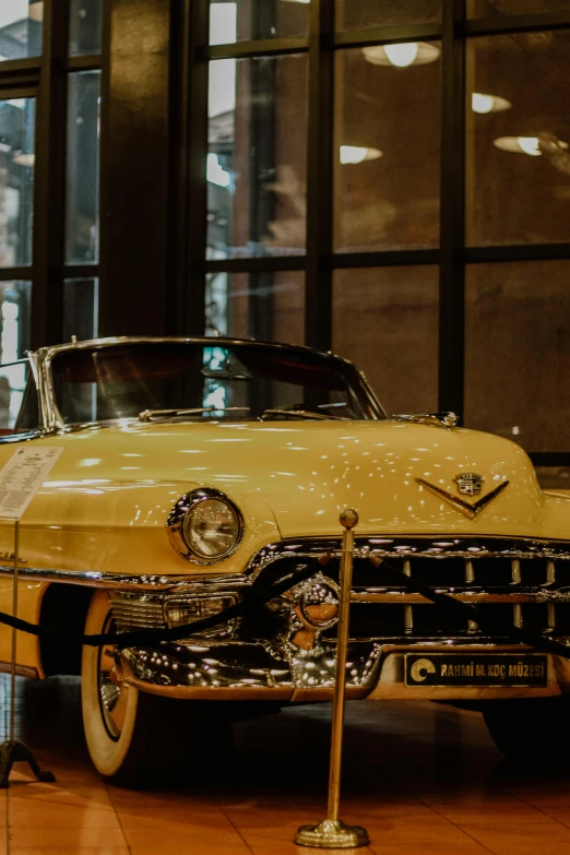 a vintage yellow car that is in a museum
