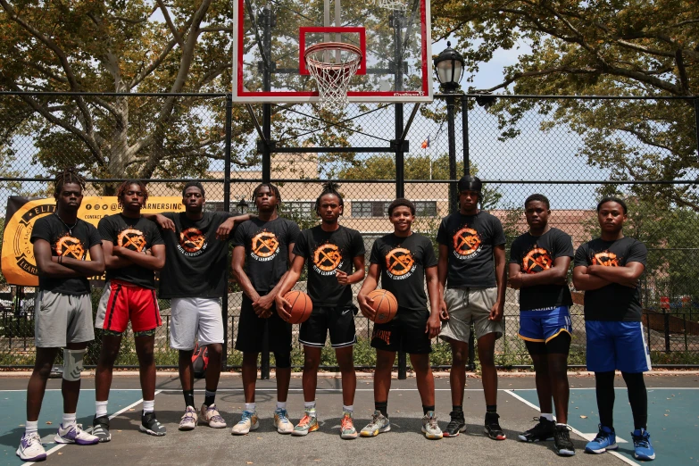 the basketball team poses for a po with their orange ball