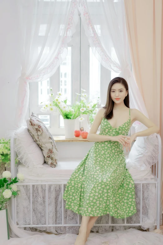 a woman sitting on top of a white bed next to flowers