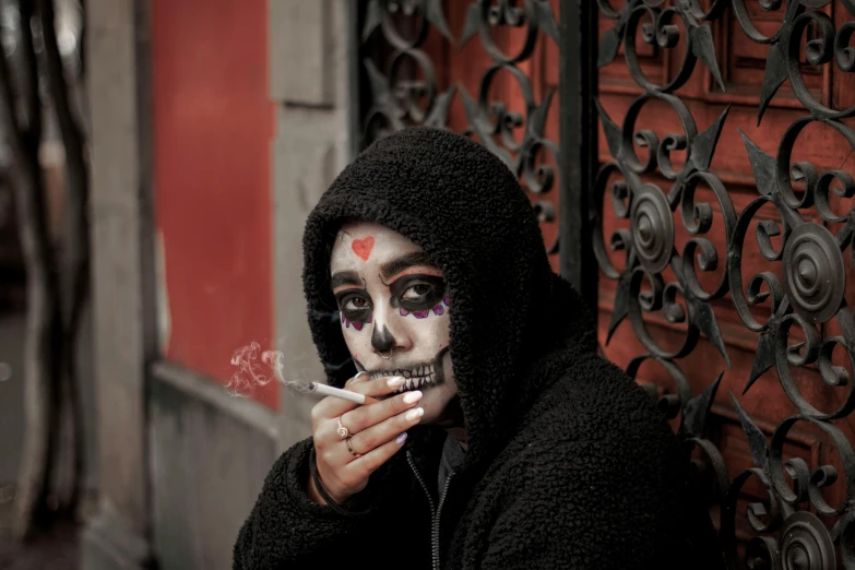 a woman with painted makeup is smoking a cigarette