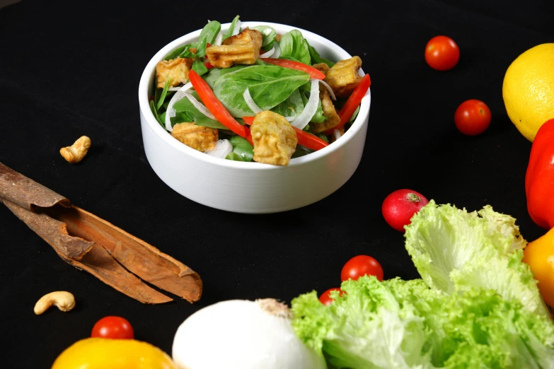 a bowl of salad with tomatoes, peppers and onions