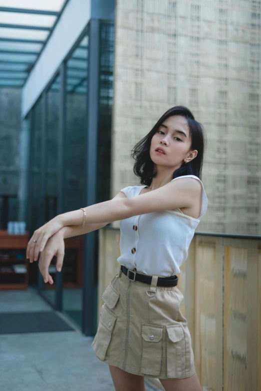 a young woman standing and holding onto the wall